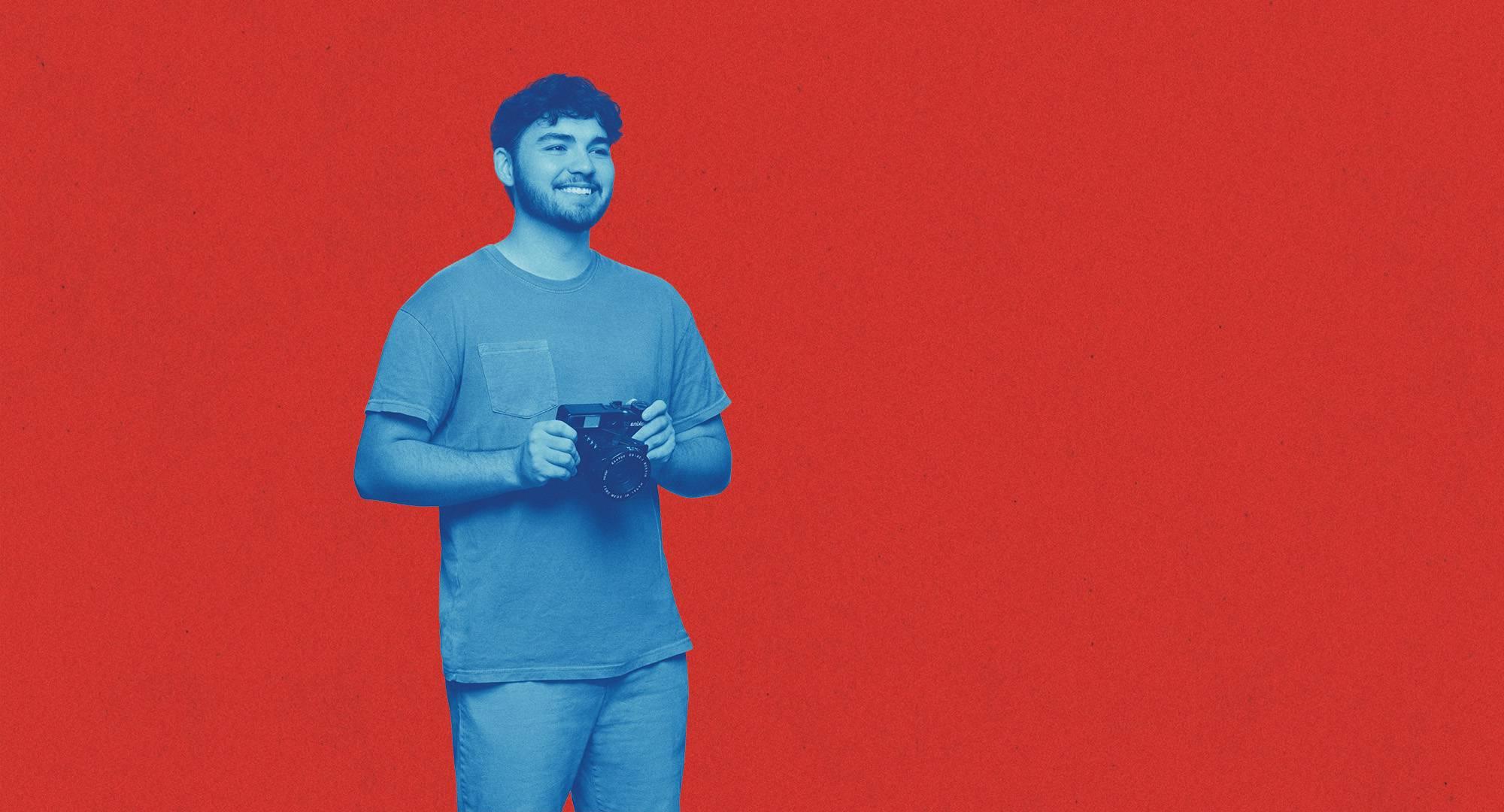 一个学生站在红色背景前，用蓝色滤镜涂上颜色.